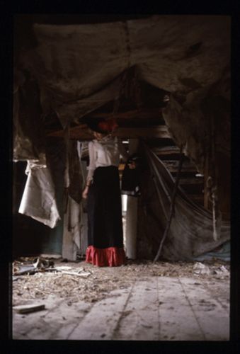 woman in period costume in junky room